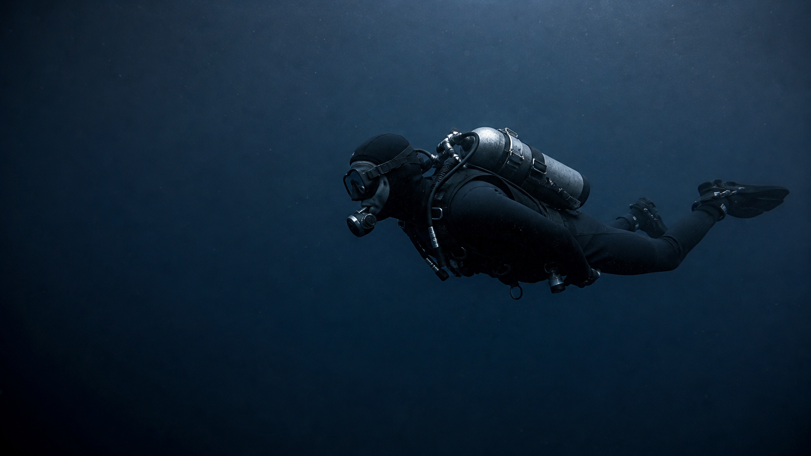 Atmospheric editorial image of a diver moving through deep open water